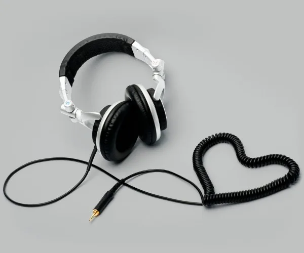 Image of a pair of over the ear headphones with the cord coiled into a heart-shape.