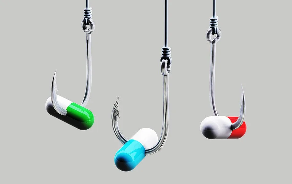 An image of three medicine capsules hanging on fishing hooks and lines against a light grey background.