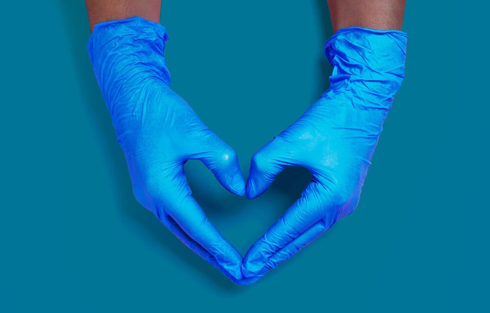 hands hanging down forming a heart shape with surgical gloves on