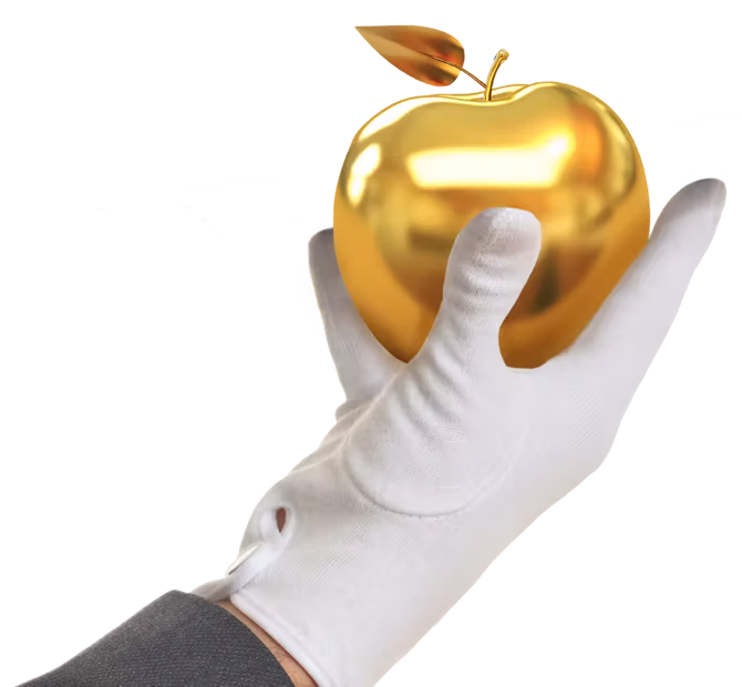 A white gloved hand holding up a shiny golden apple.